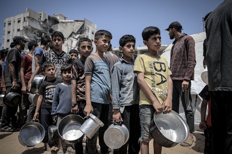 GAZA CITY, GAZA - MAY 31: Palestinians including women and children living in tents receive food distributed by aid organizations in al Mawasi district of Khan Yunis, Gaza on May 30, 2025. The situation highlights the growing desperation and urgent need for humanitarian assistance in the region. (Photo by Ahmed Jihad Ibrahim Al-arini/Anadolu via Getty Images)