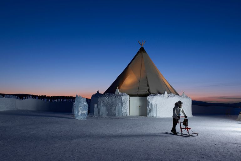 A woman uses a kick sled outside a Saami tent at the Icehotel in Sweden. The Icehotel is constructed each year from 20,000 tons of snow and 3,000 tons of ice.