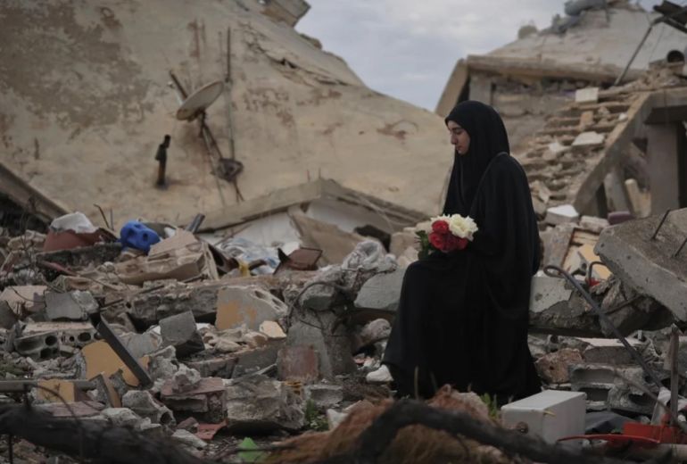 L’Orient Le Jour – Lebanon | Photographer: Mohammad Yassine; picture editor Fouad Khoury Hélou Israel-Hezbollah war; a woman from the village of Aïta el-Chaab holds roses amid the rubble in January 2025 Photograph: Mohammad Yassine/c/o Visa Pour L’Image