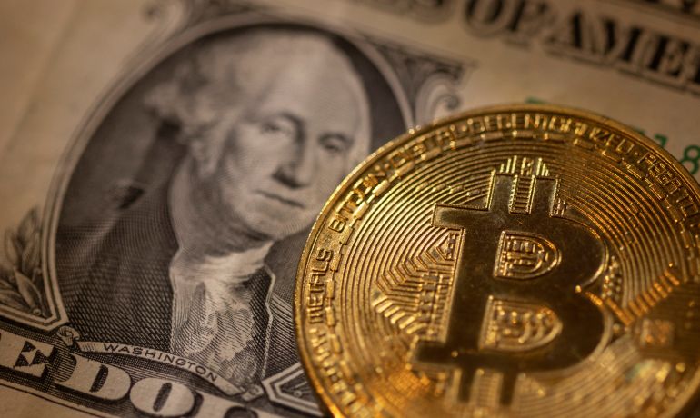 A representation of virtual cryptocurrency Bitcoin is placed on a U.S. Dollar banknote in this illustration taken November 28, 2021. REUTERS/Dado Ruvic/Illustration 2021-11-28T234405Z_20920831_RC2W3R98MYKO_RTRMADP_3_FINTECH-CRYPTOCURRENCY