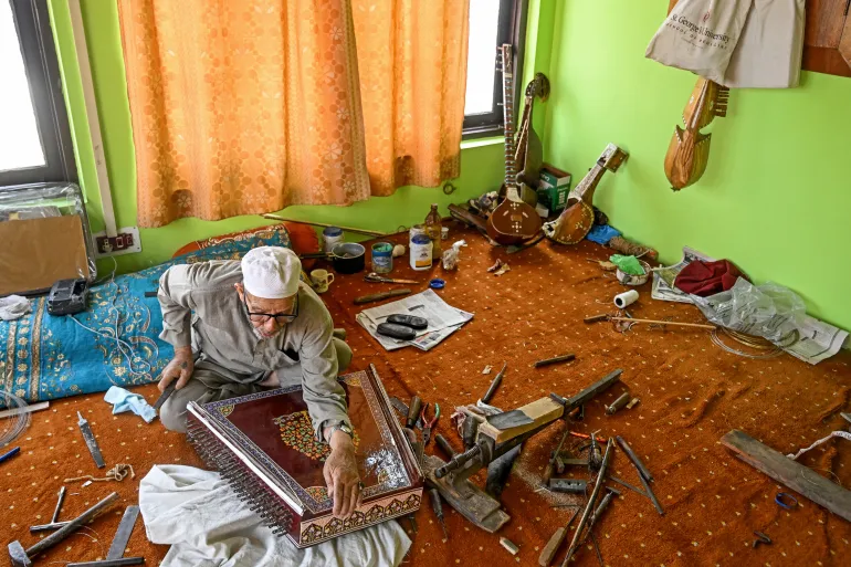 In this photograph taken on September 23, 2025, artisan Ghulam Mohammad Zaz makes the Santoor instrument at his home in Srinagar.