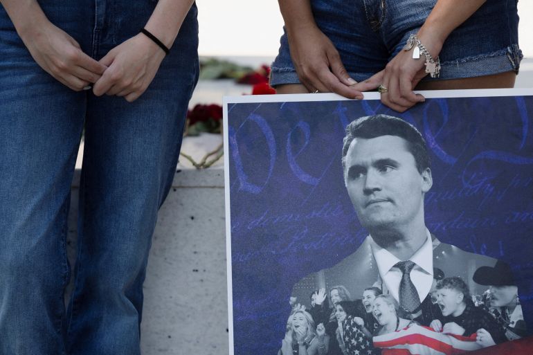 Jordyn Hackner, president of Turning Point USA's University of Houston chapter,and Lizbeth Aguilar stand behind a poster of conservative activist Charlie Kirk as people mourn following his fatal shooting, at the University of Houston in Houston, Texas, U.S., September 11, 2025. REUTERS/Antranik Tavitian TPX IMAGES OF THE DAY