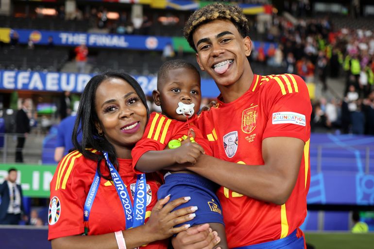 BERLIN, GERMANY - JULY 14: Lamine Yamal of Spain poses for a photograph with his Mother, Sheila Ebana, and his Brother as he celebrates victory after the UEFA EURO 2024 final match between Spain and England at Olympiastadion on July 14, 2024 in Berlin, Germany. (Photo by Boris Streubel - UEFA/UEFA via Getty Images)