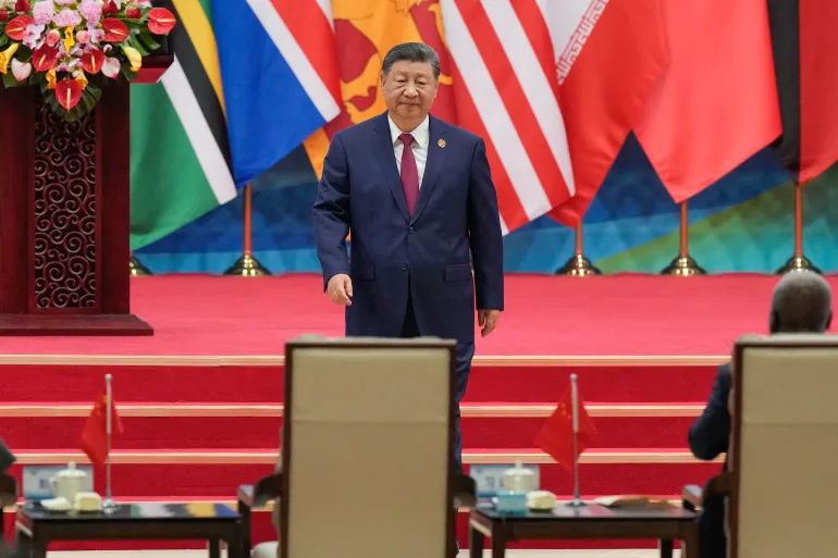 China's President Xi Jinping returns to his seat after delivering a speech during the opening ceremony of the Global Women’s Summit at the China National Convention Center in Beijing on October 13, 2025.