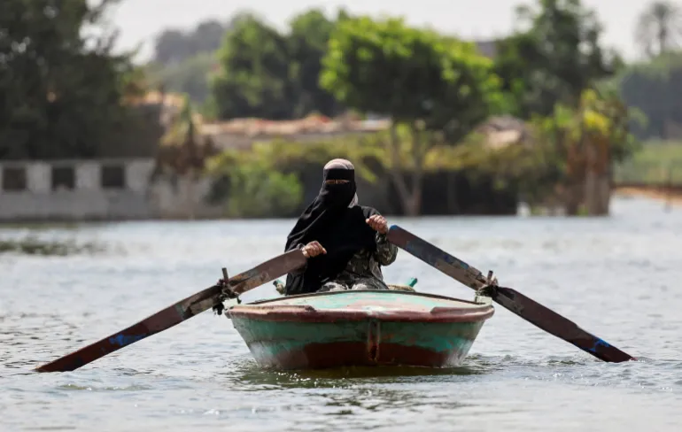 A woman rows her boat after flooding in Dalhamo Village, near the Delta city of Ashmoun, in Menoufia Governorate, Egypt, October 5, 2025. Egypt's Prime Minister Mostafa Madbouly said the government had anticipated the rise in water levels, which coincides with the flood season and Ethiopia's inauguration of its dam. He said higher-than-usual discharges are expected until the end of October, adding that the flooded areas in Menoufia and Beheira are part of the Nile's flood zone and have been encroached upon by some citizens. REUTERS/Mohamed Abd El Ghany TPX IMAGES OF THE DAY